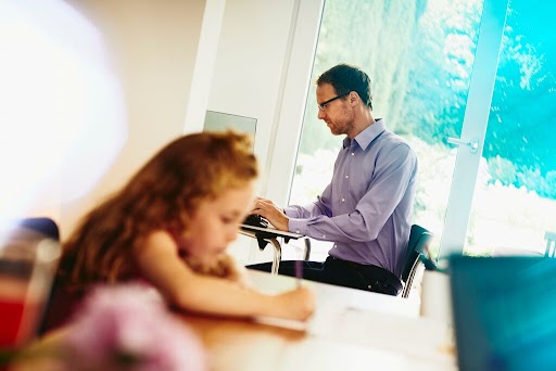 daughter and father at desks