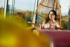 woman on phone in hanging egg chair