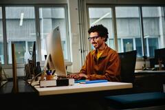 smiling male at work using desktop computer