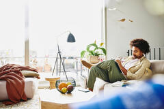 Male sitting down on a couch writing notes