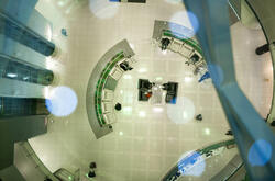 Top view of modern futuristic office hall with semicircular rows of armchairs and elevators aside.