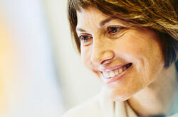 Female nurse smiling, looking away from the camera.