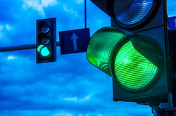 Close up of traffic lights over urban intersection.