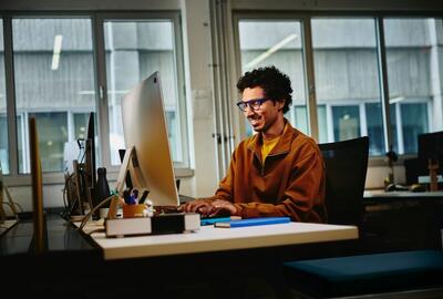 smiling male at work using desktop computer