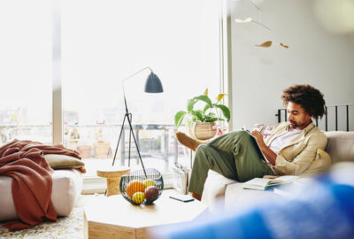 Male sitting down on a couch writing notes