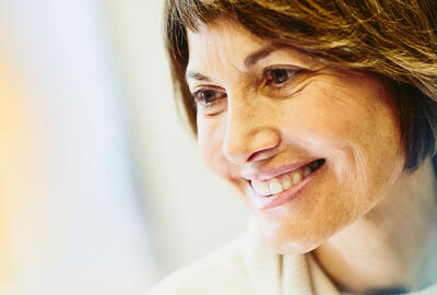 Female nurse smiling, looking away from the camera.