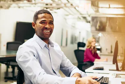 Smiling male looking away behind a desk