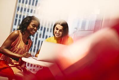 Two smiling women working together