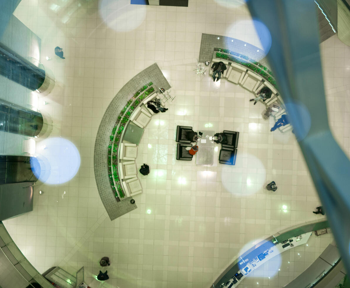 Top view of modern futuristic office hall with semicircular rows of armchairs and elevators aside.