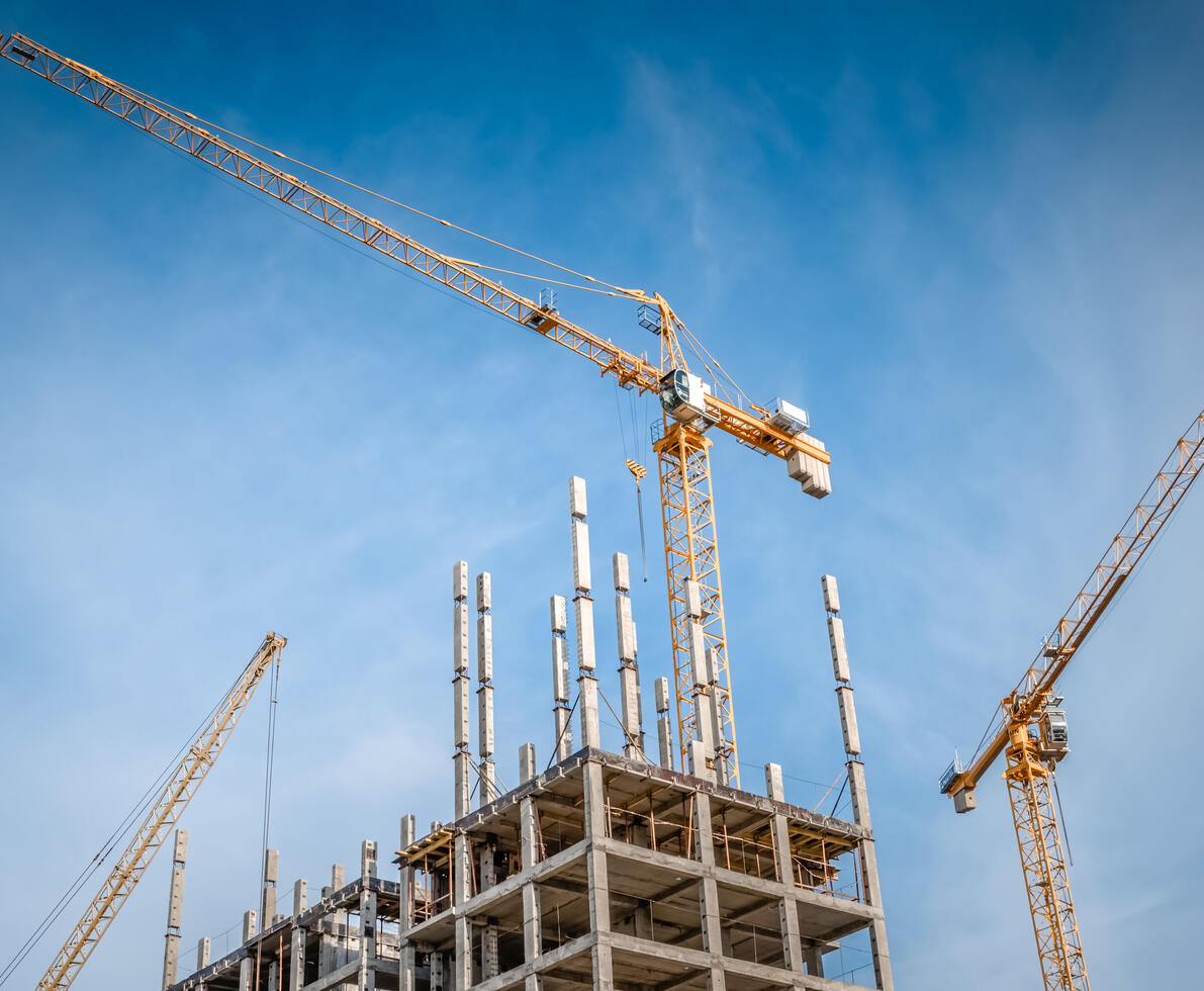 Highrise cranes and multi-storey housing under construction.