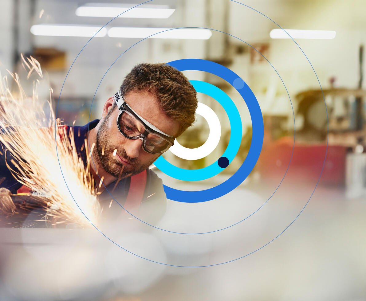 Man wearing safety glasses, grinding metal with sparks flying