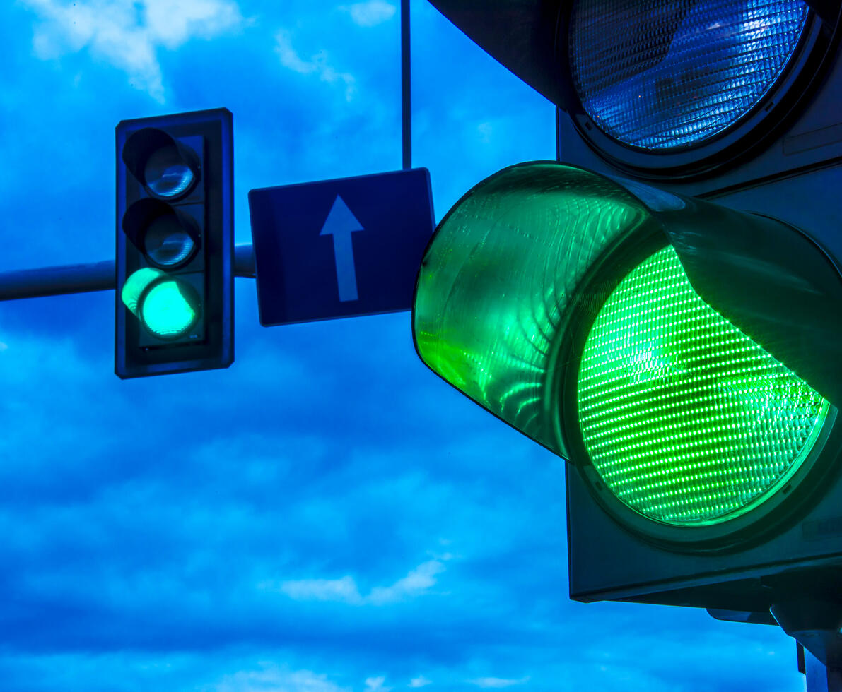 Close up of traffic lights over urban intersection.