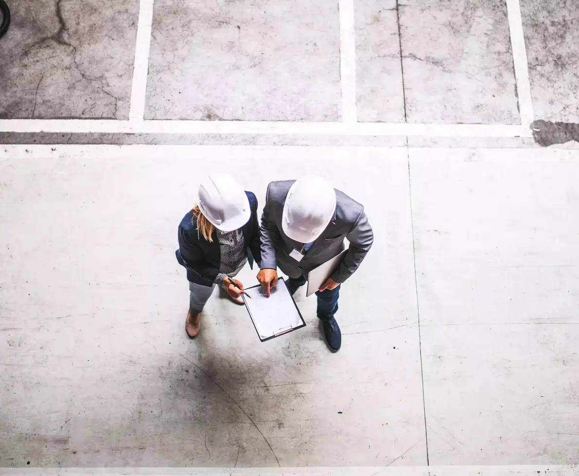 A top view of an industrial man and woman engineer with clipboard in a factory. 