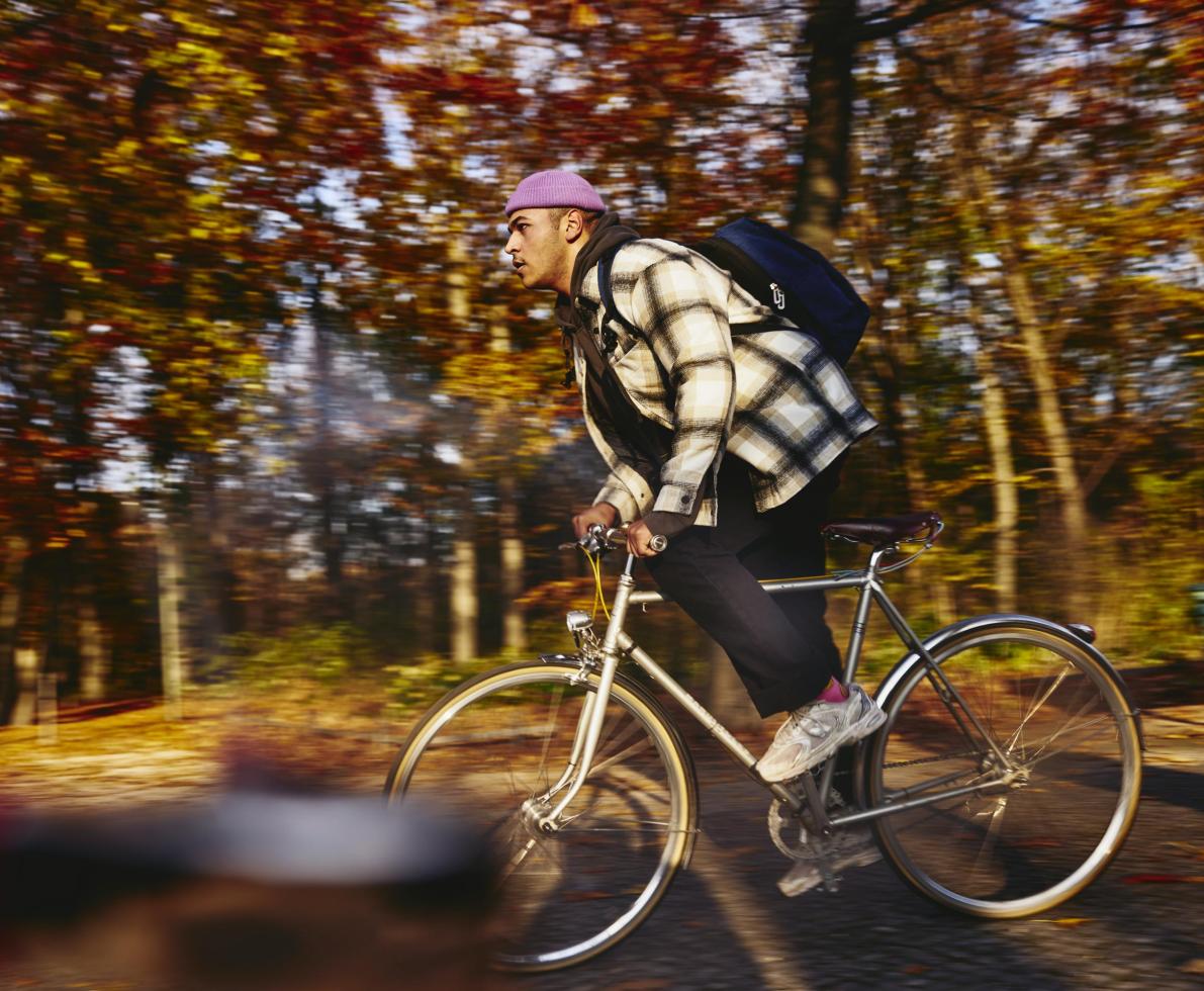 Cycling man, autumn trees on the background.