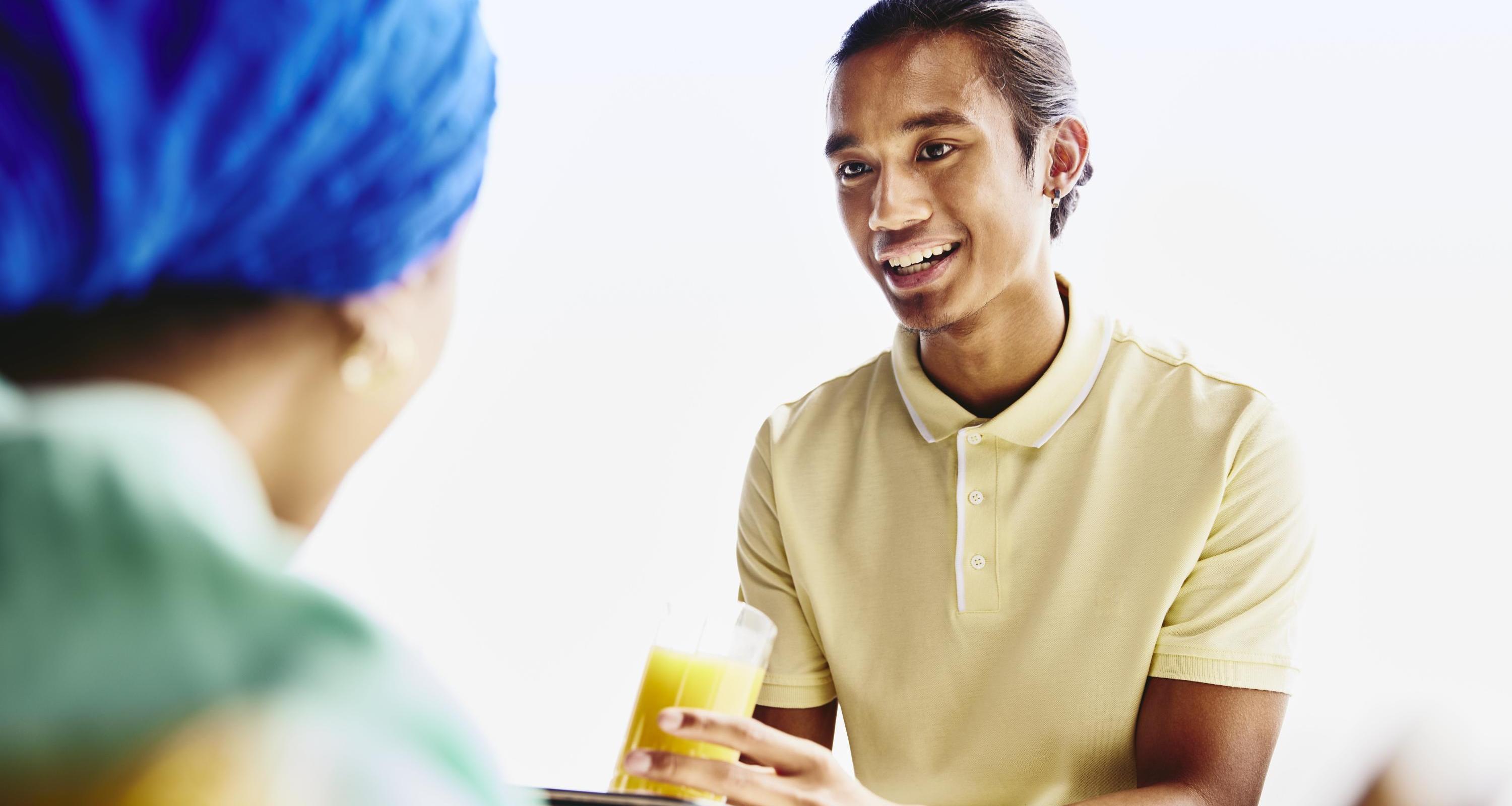 Waiter serving a drink to a woman.