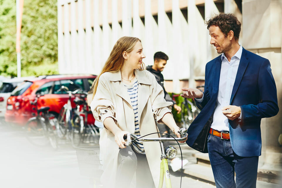 Teaching assistant talking to female student on bike