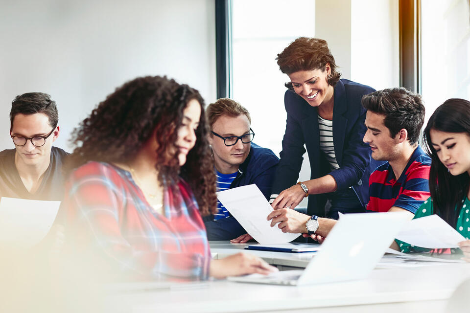 Female teacher showing students some work