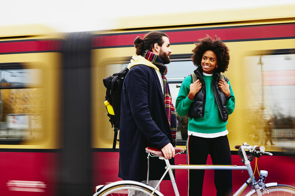 male and female standing on a train platform with a bike