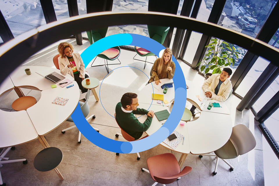 Bird view of people sitting at a round table and having a meeting.