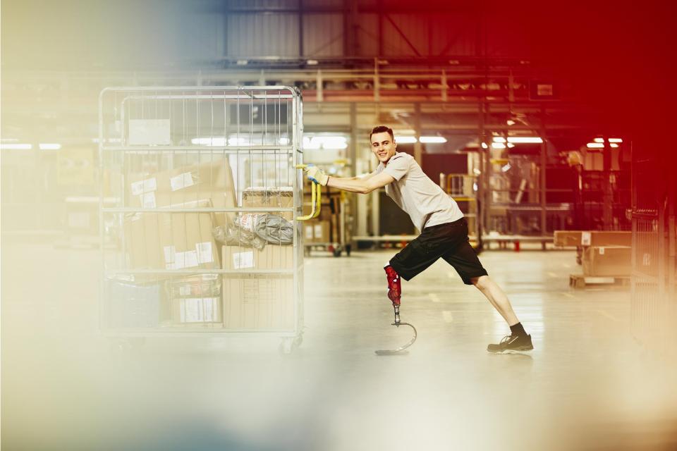 Worker pushing a trolley in a warehouse